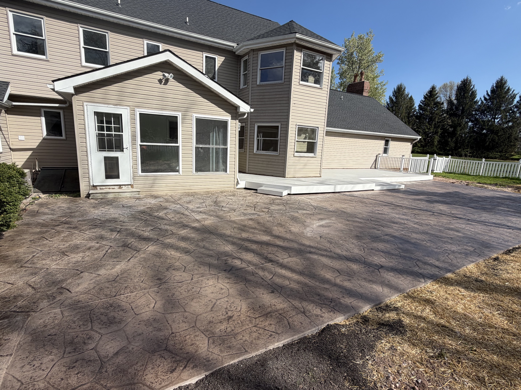 Stamped patio + outdoor living area completed by T-Bones Concrete